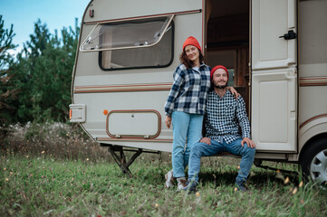 Romantic couple spending time together near trailer home. Traveling together with motor home.