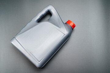 grey with a red lid canister with machine oil on a black background.