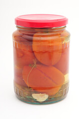 Salted tomatoes in a glass jar on a white background