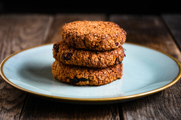 Homemade oatmeal cookies in a ceramic plate on the kitchen table.