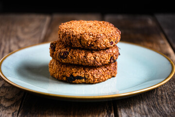 Homemade oatmeal cookies in a ceramic plate on the kitchen table.