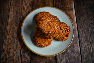 Homemade oatmeal cookies in a ceramic plate on the kitchen table.