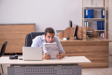 Young male employee unhappy with excessive work