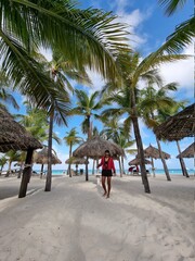 Palm Beach Aruba Caribbean, white long sandy beach with palm trees at Aruba Antilles, woman...