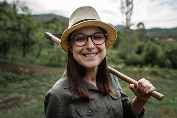 Front view portrait of young adult caucasian woman female farmer standing in the agricultural field...