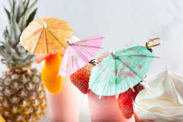 A view of paper drink umbrella garnishes decorating a selection of fruit smoothies.