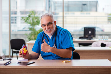 Old male doctor cardiologist working in the clinic