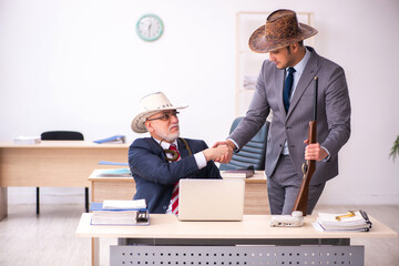 Two male cowboy employees in funny concept
