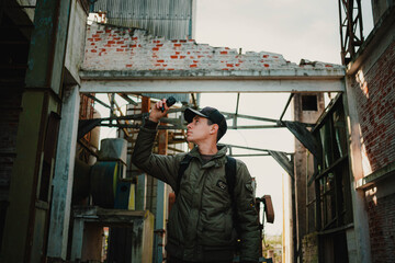 Filmmaker on recording with destroyed structure in the background