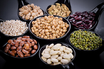 Mix nuts in black bowl on wood background
