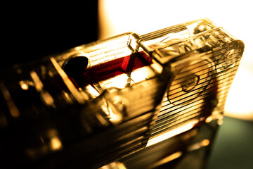 Sepia Toned Macro Closeup of Red Tape and Pinch Roller of See Through Cassette Isolated in Front of Bright Light on Black and Green Background