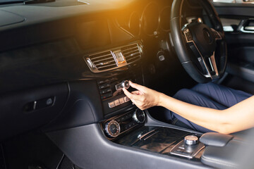 Hands woman driver turning on car air condition system,Button on dashboard in modern car panel,Auto car air conditioner