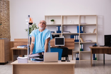 Old male employee in blood transfusion concept