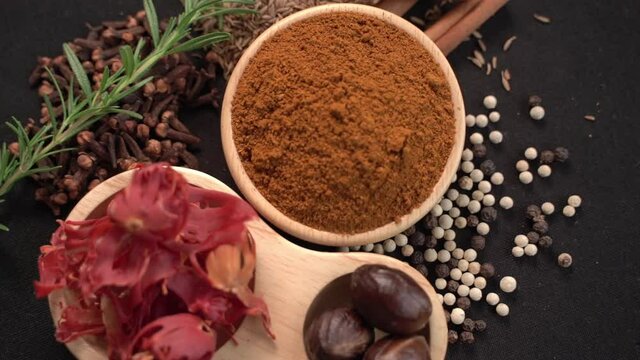 Close up of Curry powder and spices in a wooden cup with black background, industry concept