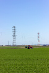 Fototapeta na wymiar 農地に立つ送電鉄塔