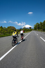 Naklejka premium Riders enjoying cycling towards the mountain
