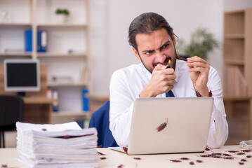 Naklejka premium Young male employee and too many cockroaches in the office