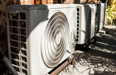 A row of Split Type Inverter Air conditioning condensers outside a cafe or restaurant. HVAC for...