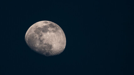 Big Moon. Dark deep blue night sky without stars. Moon with craters. View in telescope telephoto lens. Astro or astronomy photography. Little planet. Moon is Earth natural satellite. Copy space. 