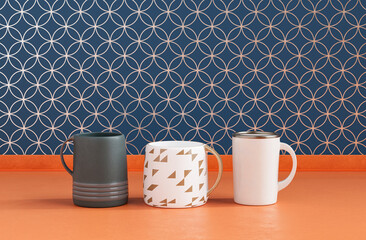 Three different coffee mugs side by side on kitchen countertop with wall, close up front view, 3d rendering, no people