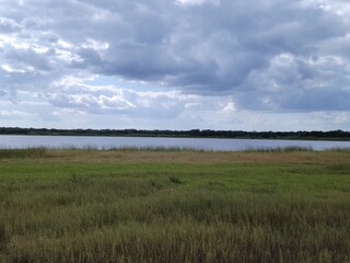 Clouds over a field and a river