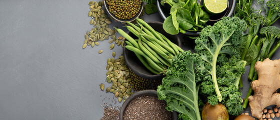 Assorted green vegetables and cereal on gray background. Healthy food concept.