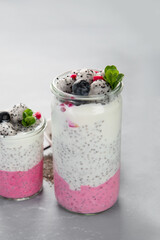 Layered chia puding with pink filling on gray background.