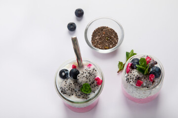 Layered chia puding with pink filling on white background.