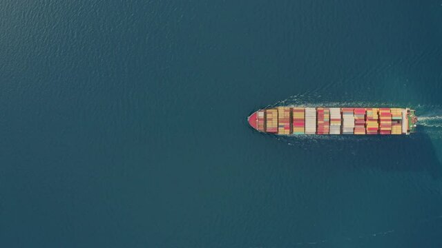 Aerial top view large cargo vessel ships under drone.Freight ship full of containers.Huge marine craft shipping import export cargo.Concept of sea transport logistics carriage.High quality 4k footage