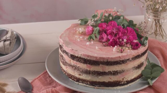 Strawberry cake, strawberry sponge cake with fresh strawberries and sour cream on a pink background.