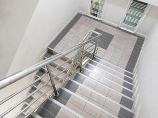Modern staircase with metal stair nosing and aluminium railing handle for safety.