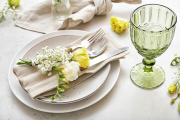Beautiful table setting with floral decor on light background, closeup