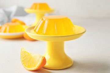 Dessert stand with tasty orange jelly on white background