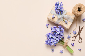 Composition with bouquet of beautiful hyacinth flowers and gift box on color background