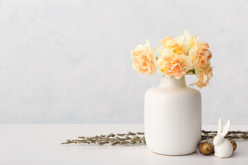 Beautiful Easter composition with narcissus flowers and quail eggs on light background