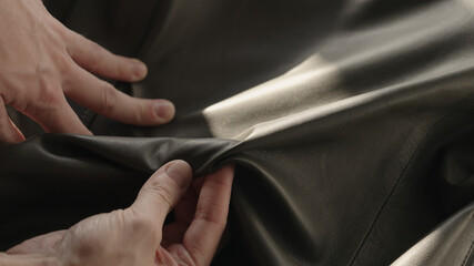 Man hand touching soft leather with sun shining from a window