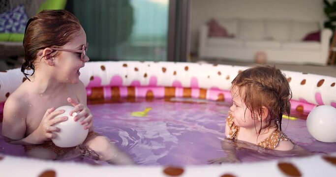 happy kids relaxing in inflatable pool at home patio, summer activities