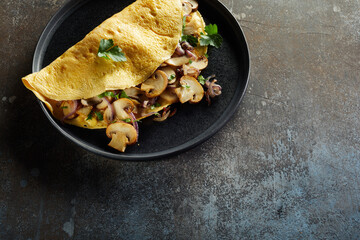 Delicious omelet stuffed with mushrooms on plate