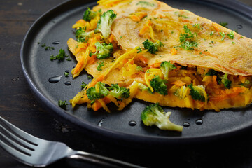 Plate with omelette near fork on table