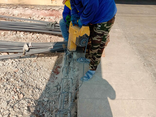 Construction workers used a jackhammer to drilling old cement flooring in the construction area.