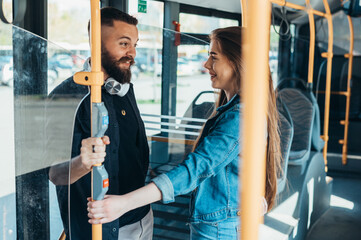 Young couple standing in a moving bus while talking
