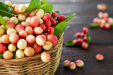 Bengal Currant or Christ's Thorn in wicker basket. summer tropical Mango Yawn with Lime red Citrus fruits herb in thailand. flat lay with copy space. food for good health concept.