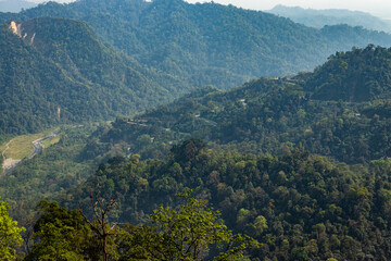 mountain range with dense green forests at morning from flat angle
