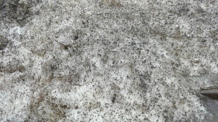 Uneven porous black and white structure. Foamed plastic consisting of cells of various shapes and volumes creates an uneven texture of the material in a square white-blue matrix.