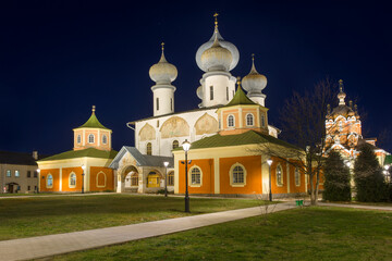 Fototapeta na wymiar Assumption Cathedral of the Tikhvin Theotokos Assumption Monastery in the night illumination of the December snowless night. Tikhvin, Russia