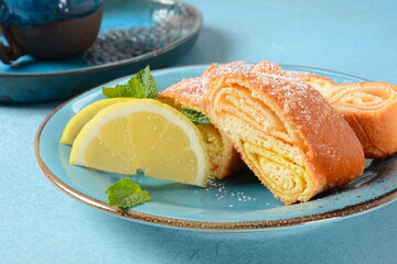 Austrian strudel with lemon and mint and with powdered sugar on a plate. Cake with orange and lemon jam