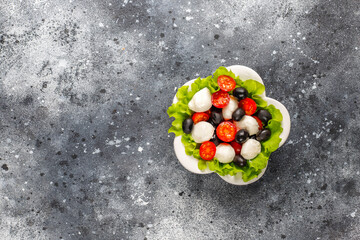 Salad with mozarella cheese, olives and cherry tomatoes.