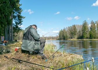 landscape with a lake, a fisherman on the shore of a lake fishing for fish, a calm water surface...