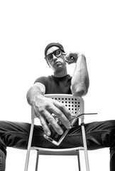 young man sitting on a chair in sunglasses with a cocktail, black and white picture.