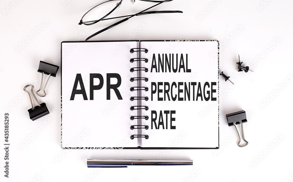Poster notebook with apr annual percentage rate on table with office tools